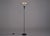 Postmodern floor lamp in steel and aluminum, equipped with a movable reflector pierced by a lens symbolizing the eye of...