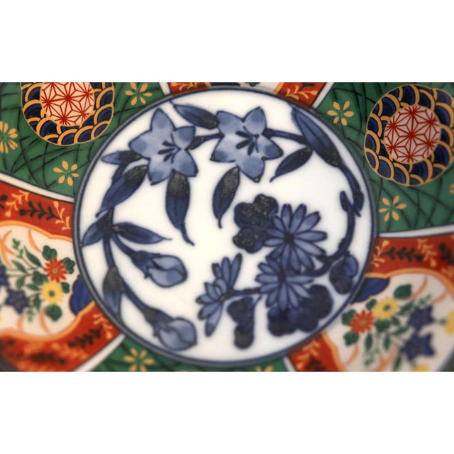 Five Imari shallow bowls are the most delicate and colorful hand painted pieces with gilt, blue, green and white flowers....