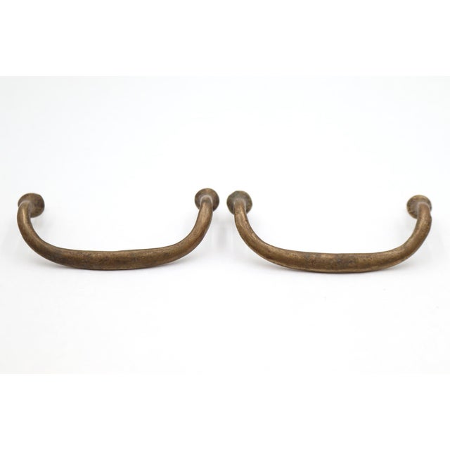 Vintage drawer pulls made of brass with a thin curved bridge design. The original mounting screws are included. Good...