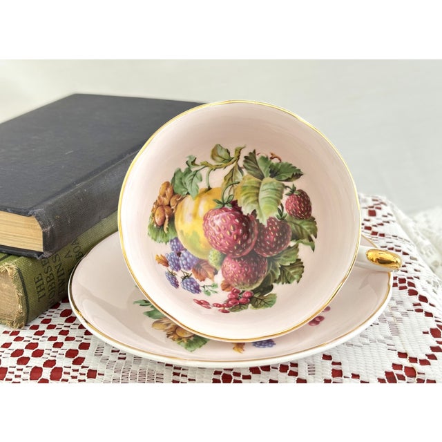 This vintage fine bone china teacup and saucer set was crafted by Royal Grafton in Staffordshire, England. Featuring an...