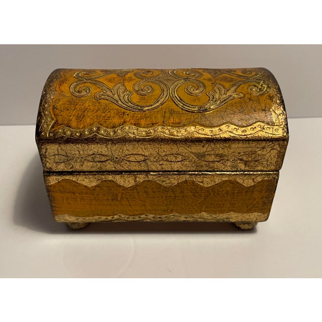 1960s Florentine style gilt and mustardy painted casket form box with with bun feet. Marked "CE Made in Italy" on the...