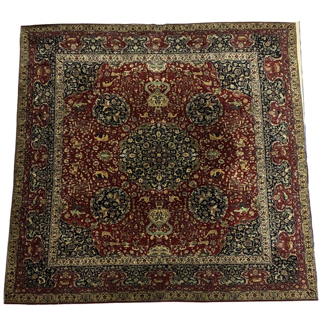 A striking hand-knotted square area rug featuring an elaborate Persian-inspired hunting and garden scene. The deep brick-...