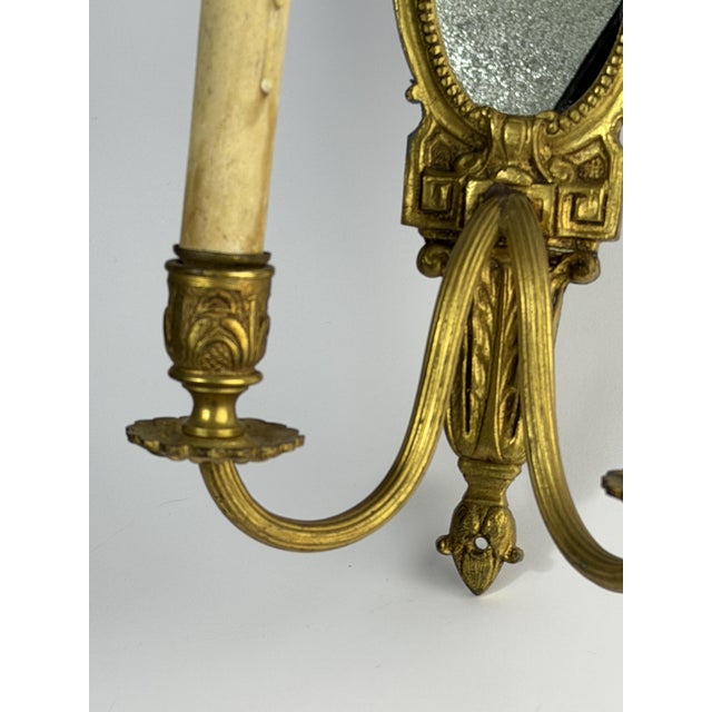 Elegant antique wall sconce with mirror, crafted in Europe around the turn of the 20th century, most likely in France....