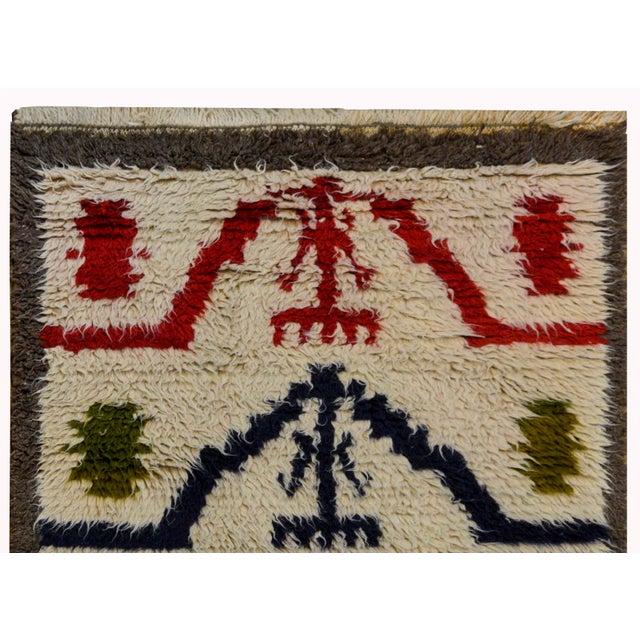 A wonderful vintage Turkish Tulu rug woven with shaggy Angora wool with a tribal pattern containing several crimson and...