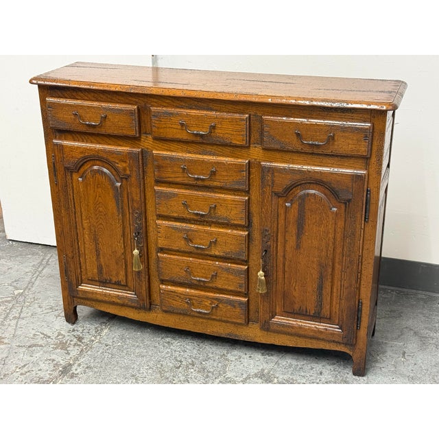 Design Plus Gallery presents a Traditional Distressed Oak Eight-Drawer Entree/Buffet. Constructed from wood in a honey-...