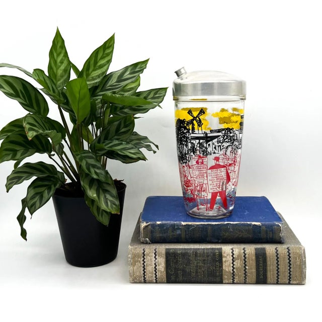 A delightful vintage glass cocktail shaker featuring a charming Parisian street scene complete with the Eiffel Tower, a...