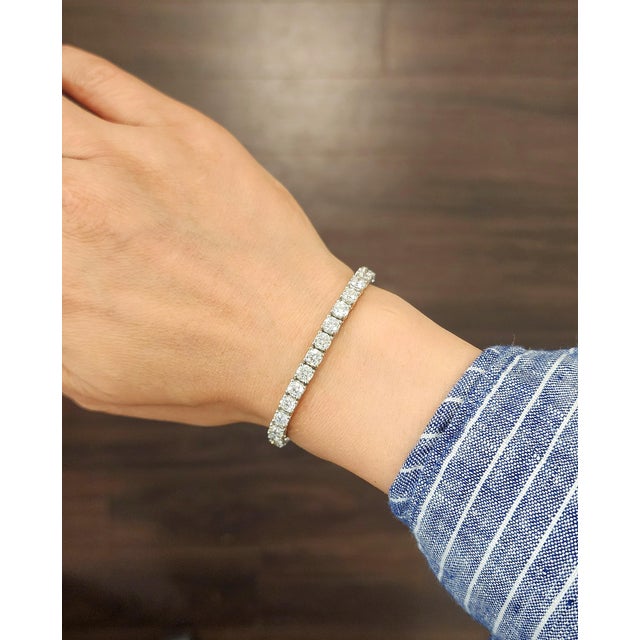 This elegant tennis bracelet embodies a modern design. It features a seamless row of38 natural round white diamonds, each...