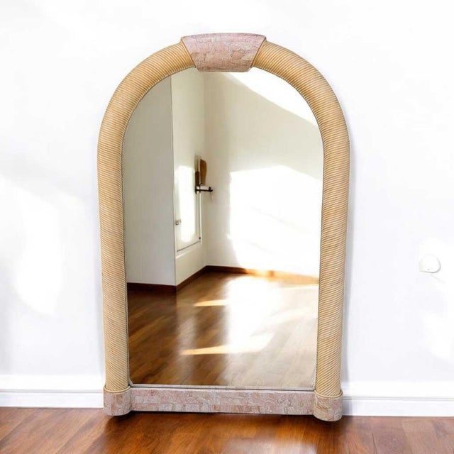 1980s Postmodern Tessellated Stone Arched Wall Mirror. A sculptural arched mirror framed in pale tessellated stone with...