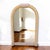 1980s Postmodern Tessellated Stone Arched Wall Mirror. A sculptural arched mirror framed in pale tessellated stone with...