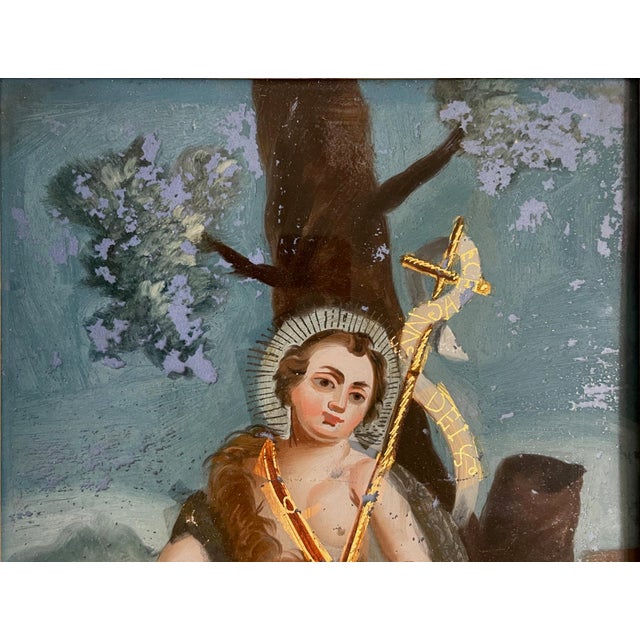 A one-of-a-kind antique, hand-painted, reverse painting on glass depicting Saint John the Baptist as a child, shown with...