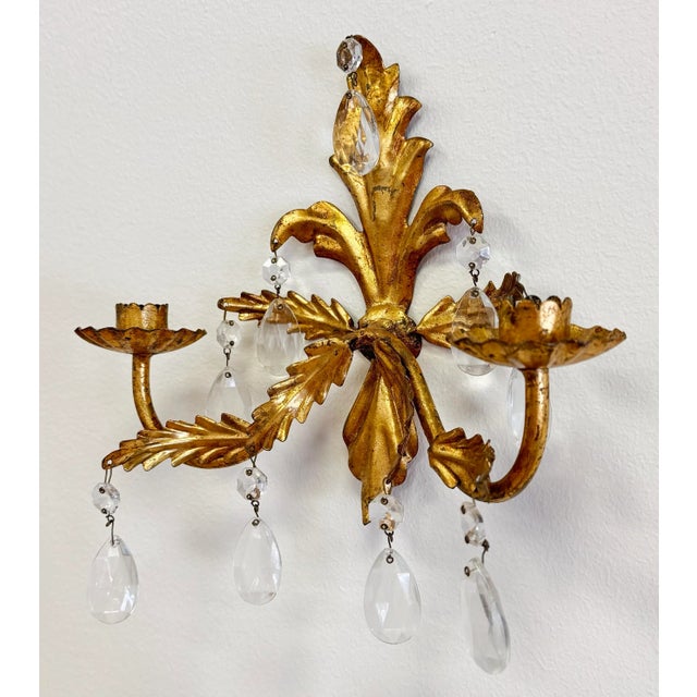 Glamorous Hollywood Regency style pair of vintage Italian gilt metal sconces with crystals. Each sconce features a myriad...