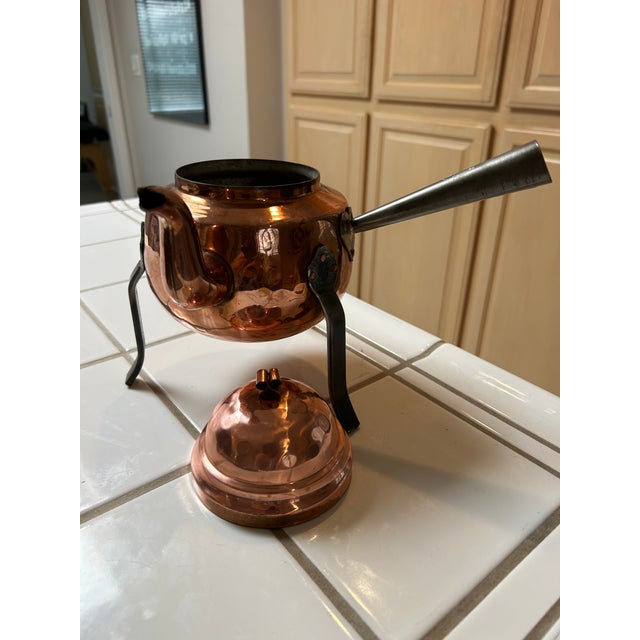 Mid to Early 20th Century Scandinavian Copper Teapot with lid. Standing on three wrought iron legs with a curved spout and...