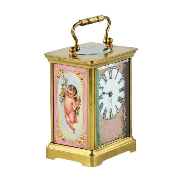 French carriage clock in a brass case, with gilded and painted porcelain panels, in the spirit of the third rococo. On a...