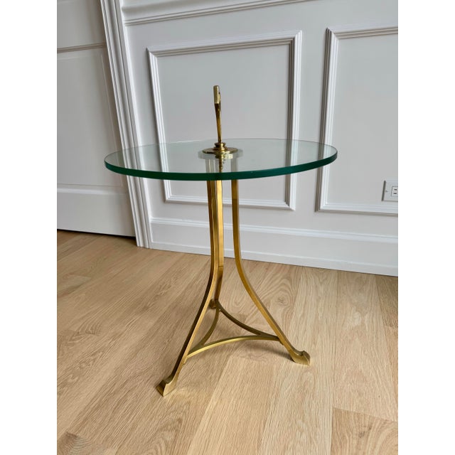 A sophisticated 20th-century drinks table featuring a minimalist tripod base in solid brass. This piece seamlessly blends...