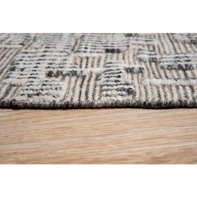 This hand knotted pile rug is crafted from wool and features a primary color palette of ivory, beige, cream, and white. It...