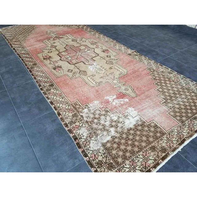 This is a vintage Turkish Oushak rug from the 1960s. The piece was hand-knotted.