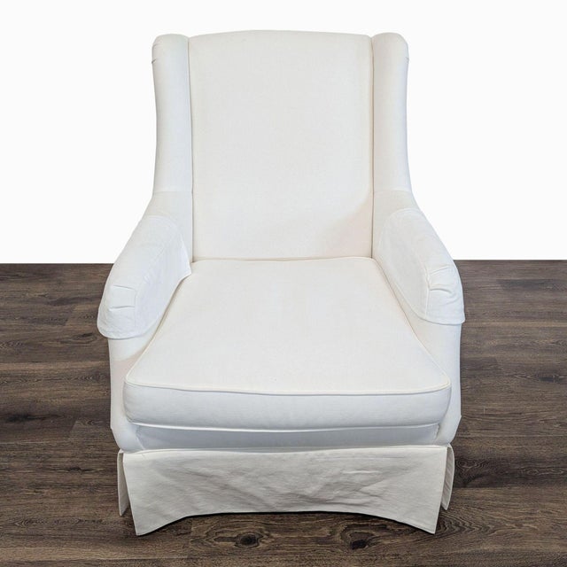 This Ethan Allen lounge chair features a clean white fabric and a supportive cushioned seat. The sleek design with gently...