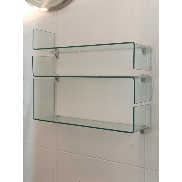 A set of three Mod. Babila wall shelves in curved glass with chrome-plated metal brackets, manufactured by Fiam Italia....
