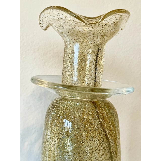 Stunning pair of candleholders from Maestri Vetrai. Hand-blown of Murano glass, the slender bodies have brilliant gold...