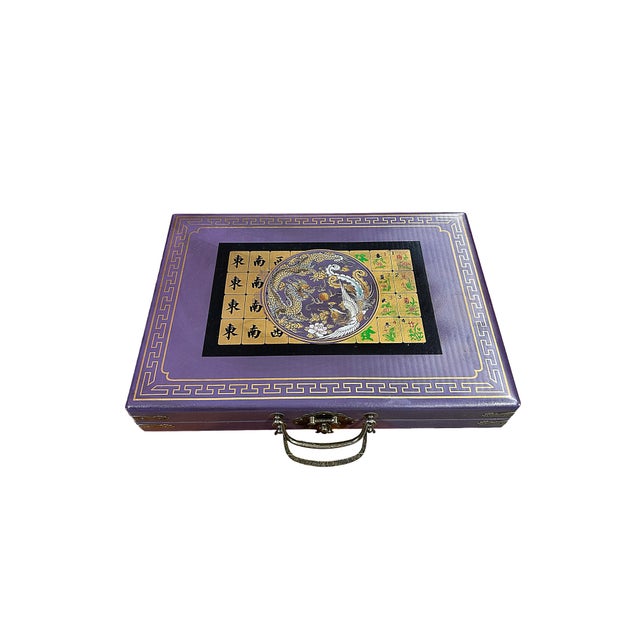 This is a traditional Chinese tile game set - Mahjong. The box surface is a purple color vinyl with an oriental scenery...