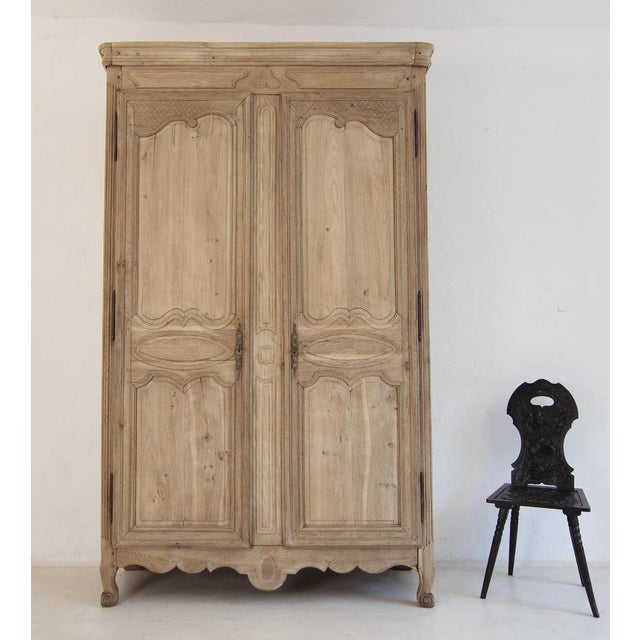 Early 19th-century French provincial wardrobe or armoire. Crafted from solid oak with a beautiful bleached finish. A fine...