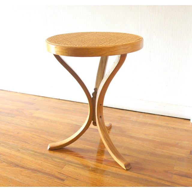 This is a an elegant mid century modern martini table by Thonet. It has a round caned top on wood, with a curved bentwood...