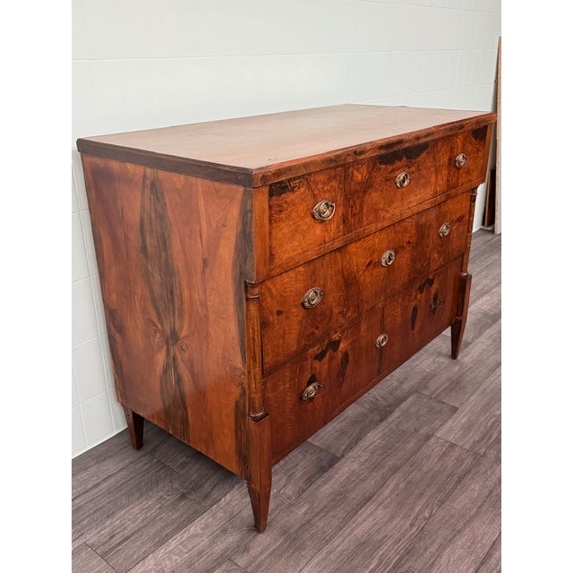 German Biedermeier-style walnut chest of drawers. Elegant ebonized side columns on both sides. It has three drawers, each...