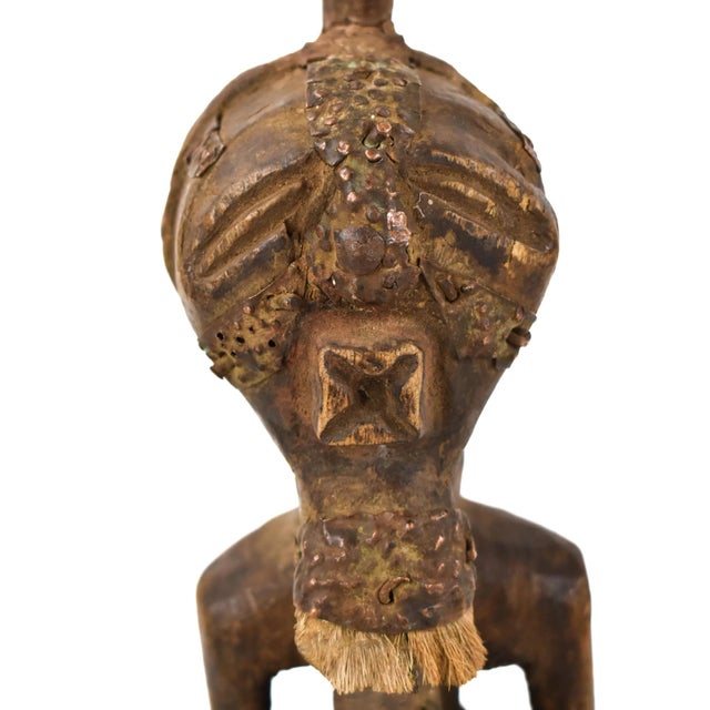 A well-carved Songye standing figure, this Songye man stands with his hands on his prominent belly. The facial features...