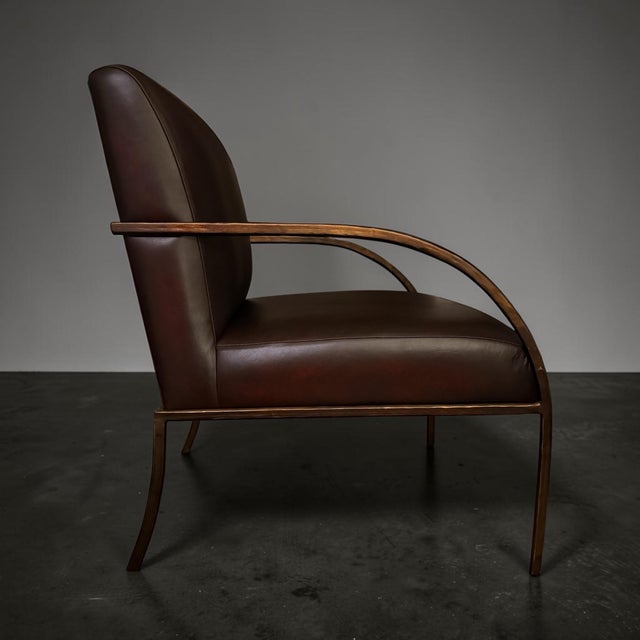 Designed by Global Views, the Swoop Chair features a graceful continuous bronze-finished iron frame wrapped around a...