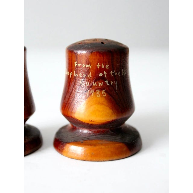 A charming pair of vintage wooden salt and pepper shakers, dated 1935 and hand-painted in yellow with the inscription,...