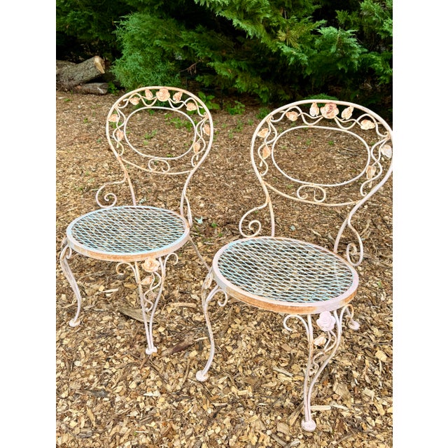 A romantic three-piece wrought iron garden set in the iconic “Chantilly Rose” pattern attributed to Woodard of Owosso,...