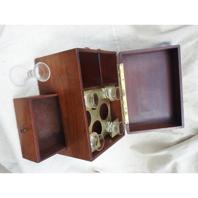 Mahogany Tantalus bar set. Have four shot glasses with etched ducks. Glass measure. Brass handles on each side and pull...