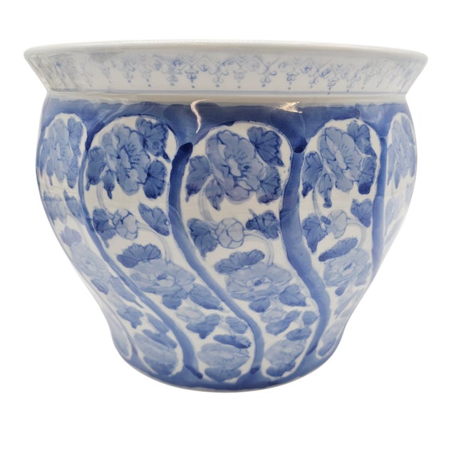 Delicate vines wind upward like music on parchment, their cobalt leaves tracing the glaze in old rhythm. This...