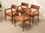 A handsome set of four vintage Danish modern dining chairs featuring sculpted warm wood frames and rich rust-toned...