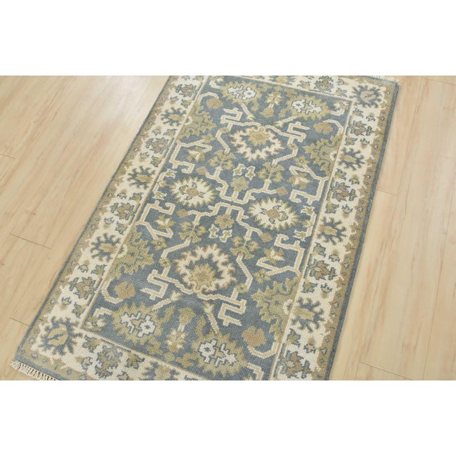 This traditional Oushak rug is hand-knotted with an all-wool pile on a cotton foundation. This rug is new and in excellent...