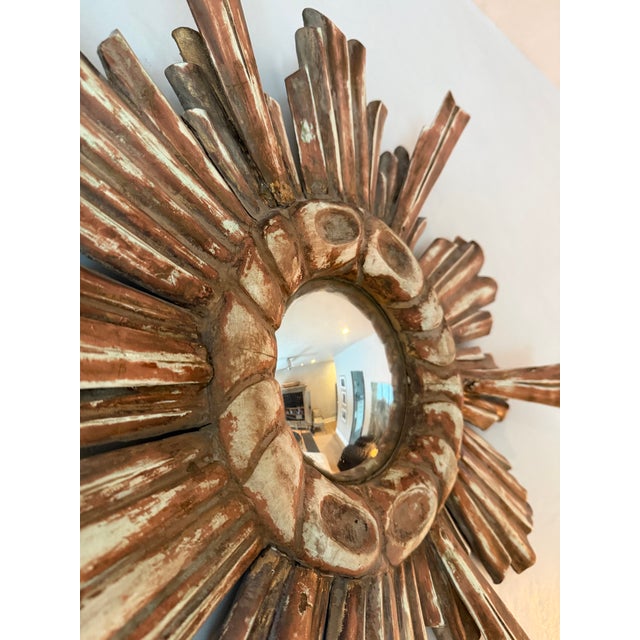 A beautiful carved sunburst mirror made of stained wood. Rare double wood rays. The mirror plate measures 5 inches in...