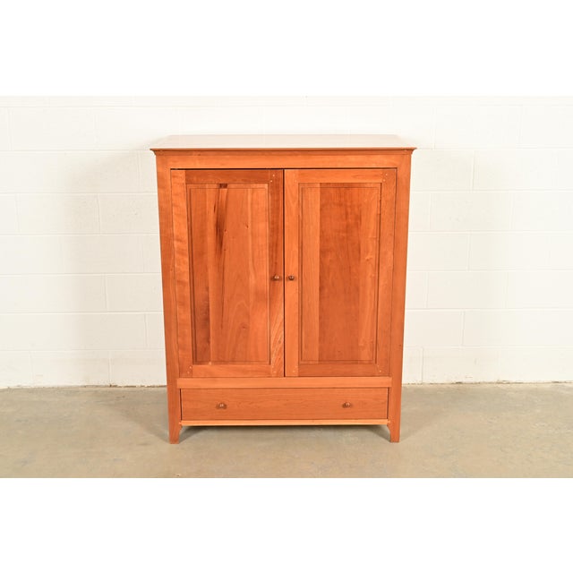A beautiful Arts and Crafts or Shaker style media cabinet or armoire By Harden Furniture USA, Circa Late 20th Century...