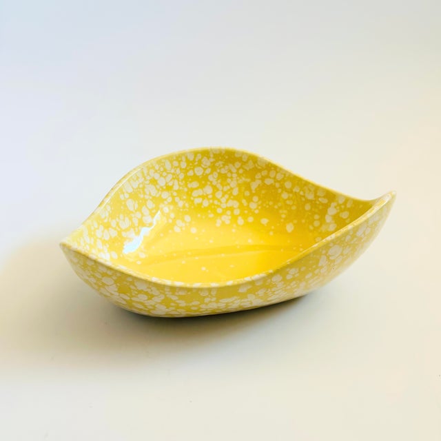 A mid century California pottery bowl. Nice free form shape, finished in a glossy speckled yellow glaze. Measures 8"W x...