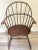 This wood Windsor style sack back back arm chair features a sculpted oval saddle seat, 10 back spindles, turned legs and...