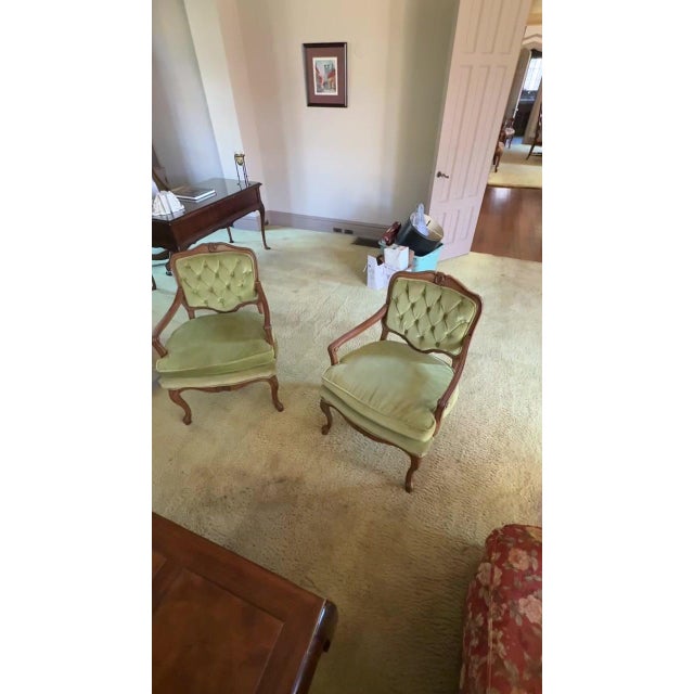 Classic pair of French fauteuils with carved wood frames, button tufted backs and sage green velvet cushions. • Set of 2...