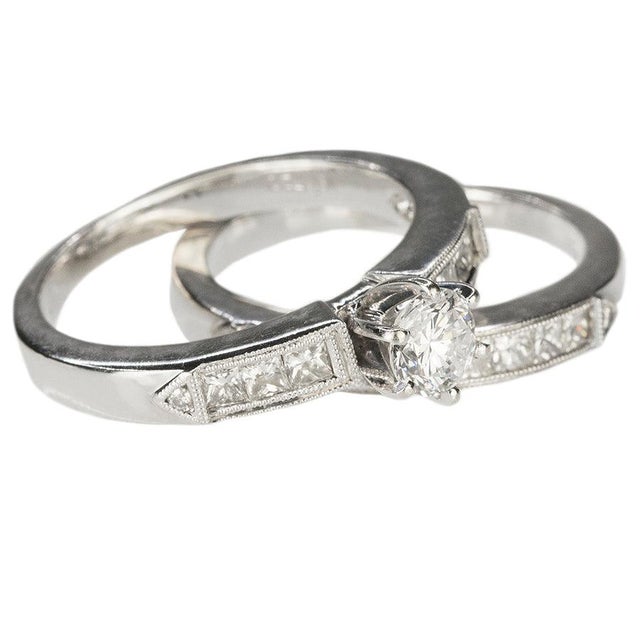 18k White gold ring with one 0.57 carat roiund brilliant and fifteen princess cut diamonds and four smaller round...