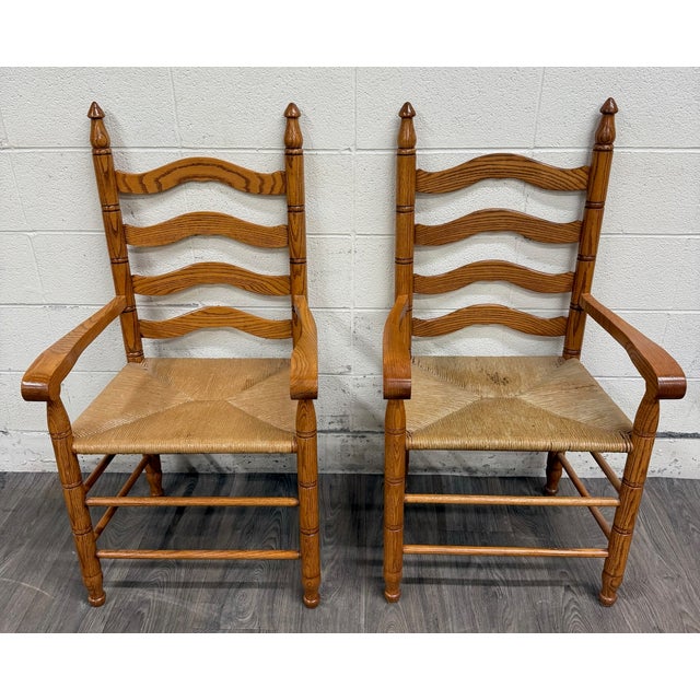 This is a gorgeous vintage pair of Country French style armchairs crafted from solid oak with traditional ladder-back...