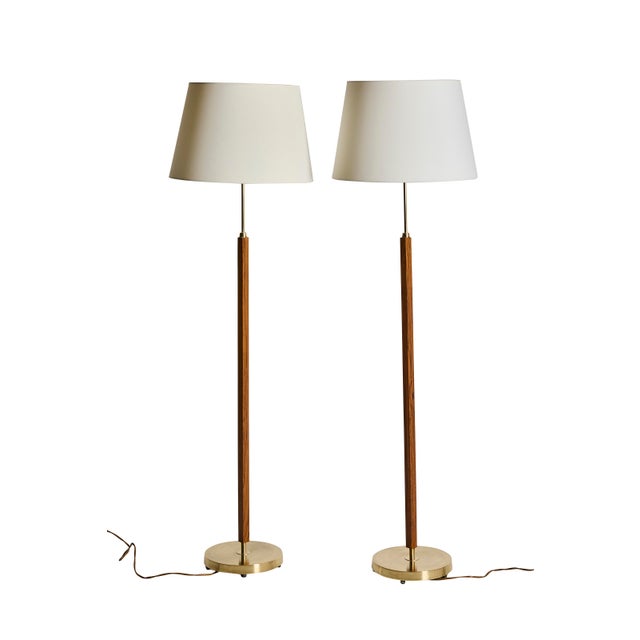A pair of floor lamps in rosewood and brass, made by Falkenbergs Belysning, Sweden in the 60s The lamps have a round base...