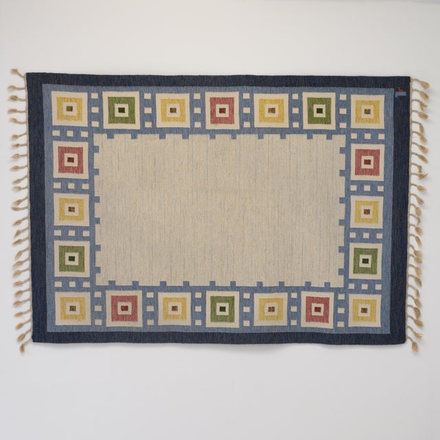 Large Swedish mid-century kilim in tones of blue and cream, an unusual colourful square border pattern. Sweden circa 1960....