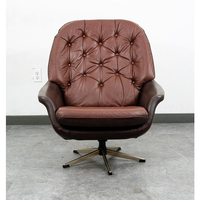 Outstanding and rarely seen tufted leather swivel lounge chair. This piece comes in a rich and high quality brown and...