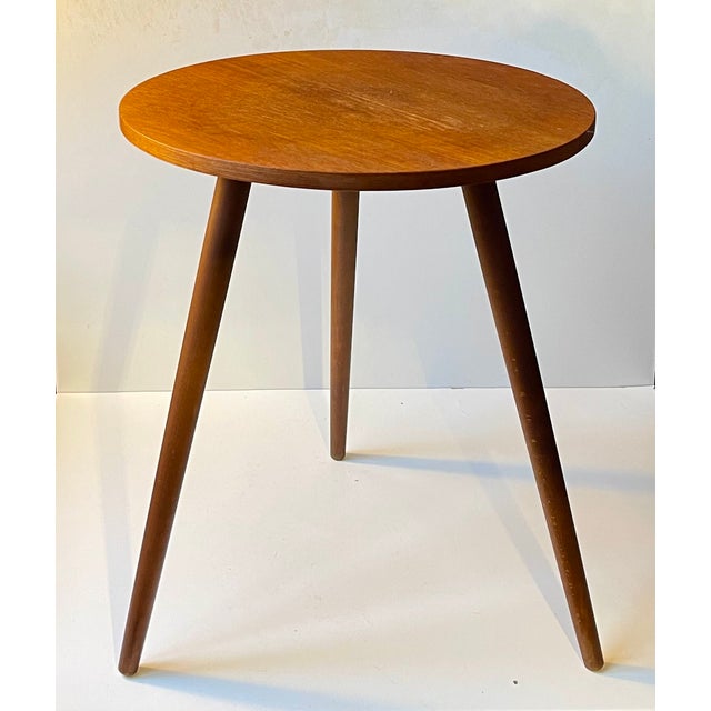 Circular side table in teak veneer resting on 3 solid tapered teak legs. It was manufactured in Denmark during the 1960s....