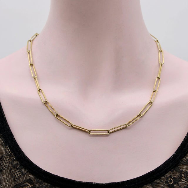 This Victorian-inspired 14k gold chain features elongated paperclip links engraved with a scalloped texture that catches...