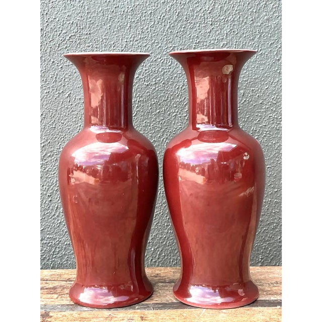 This pair of vintage ceramic vases showcases the classic baluster silhouette long favored in Chinese export porcelain...