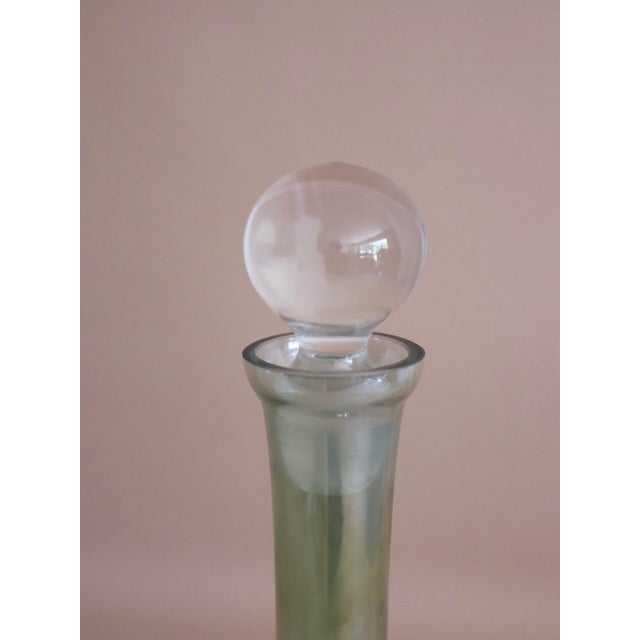 Modern luster green glass decanter with clear round topper.