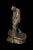 The sculpture standing man depicts a lone man standing in a boat, leaning on an oar. His hunched body, bowed head, and...